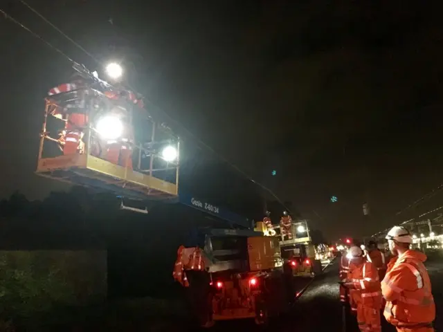 Workers repair train line cables