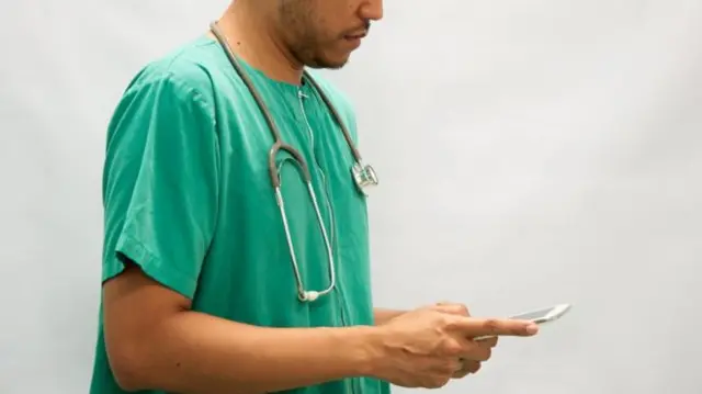 A NHS worker on his phone