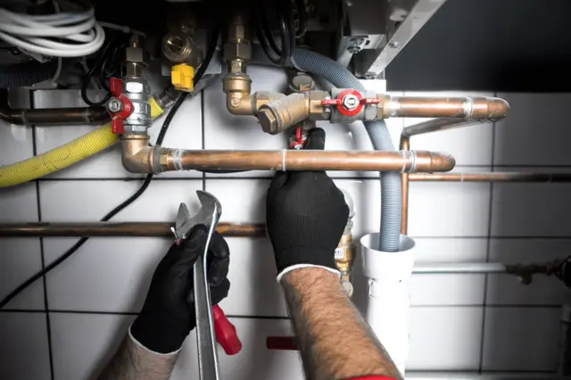 A plumber working on a boiler