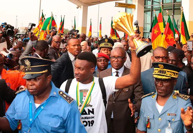 Fans cheer as Cameroon's team captain and forward Benjamin Moukandjo holds up the winner's trophy as he and the national football team arrive home to Yaounde on February 6, 2017, the day after they beat Egypt 2-1 in the finals of the 2017 Africa Cup of Nations in Libreville, Gabon.