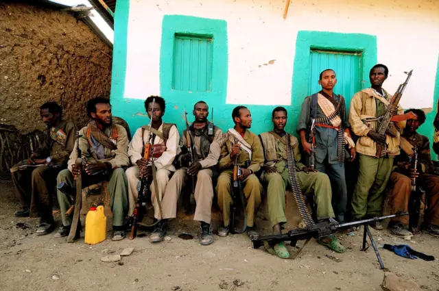 ONLF fighters sitting down outside a house