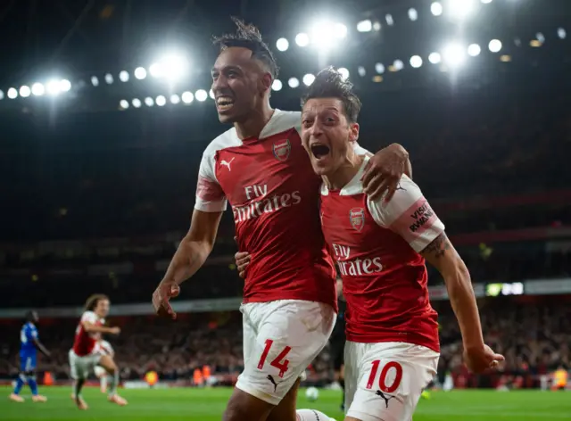 Pierre-Emerick Aubamayang of Arsenal celebrates with Mesut Ozil after scoring Arsenal's third goal during the Premier League match between Arsenal FC and Leicester City at the Emirates Stadium