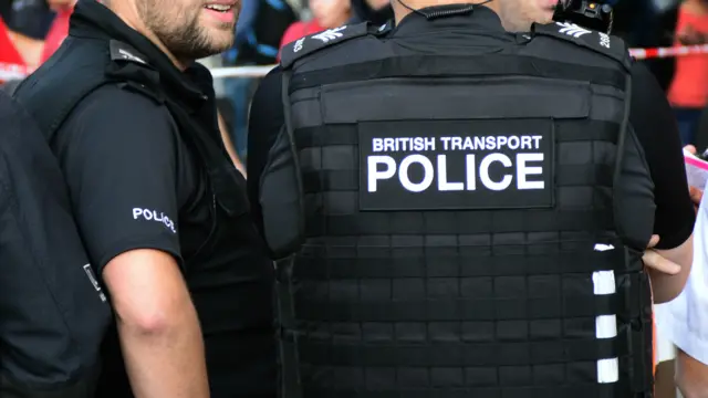 Two police officers, one with British Transport Police written on their back