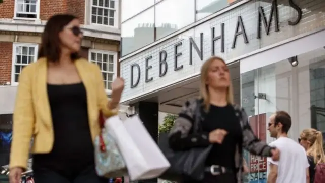 Shoppers going past a Debenhams