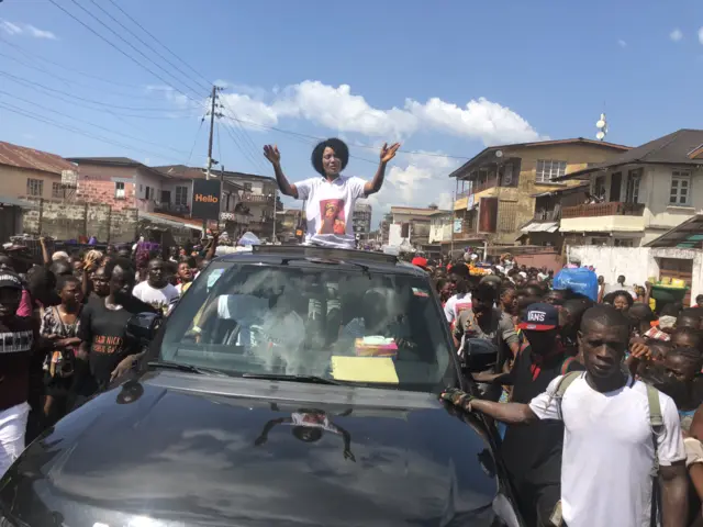 China Nicky waves to fans atop a car