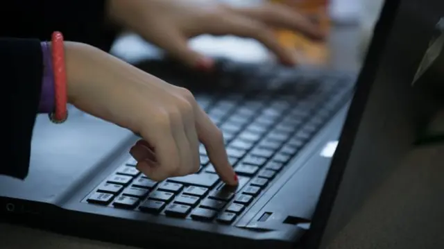 Finger on keyboard of laptop