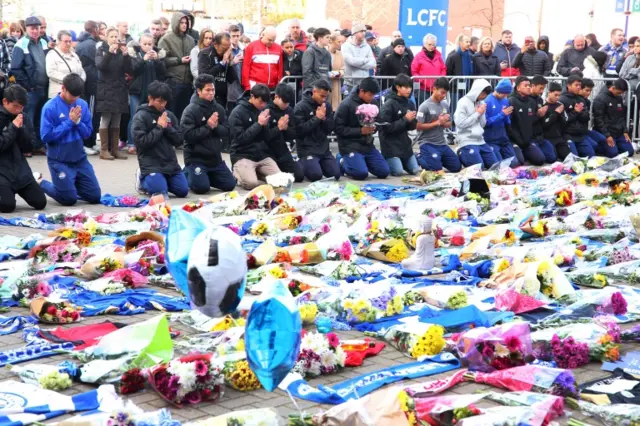 Players of the Fox Hunt Football Academy in Thailand arrive to pay their respects outside the King Power stadium in Leicester