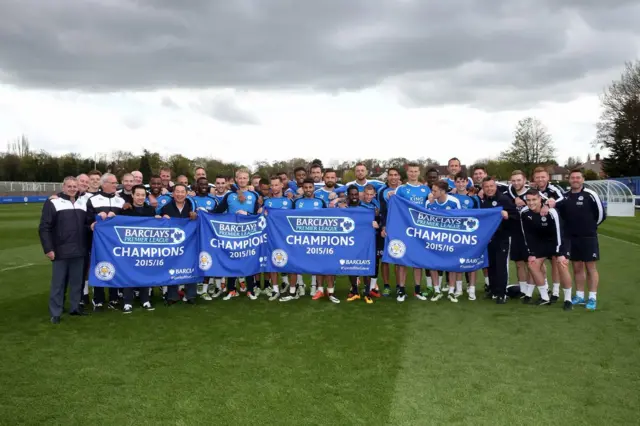 Leicester City staff and players at the club's training ground with their champions banners