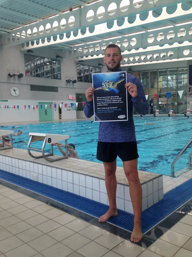 A visitor poolside at Freemans Quay in Durham with the campaign poster.