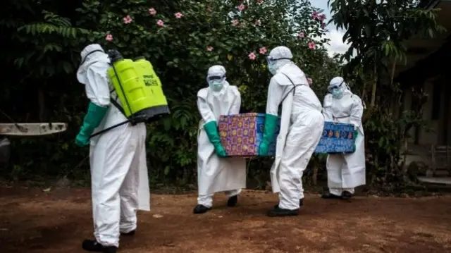 Health workers carrying a coffin