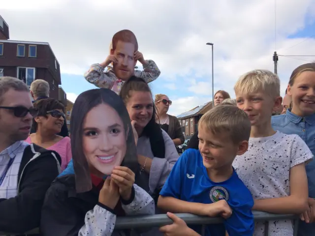 Crowds with a mask of the Duchess of Sussex