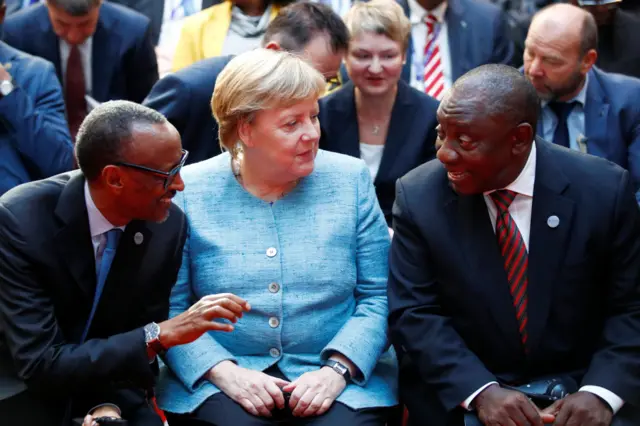 President Paul Kagame, German Chancellor Angela Merkel and South Africa's President Cyril Ramaphosa chat as they attend the G20 Investment Summit during the 'Compact with Africa' conference on trade, aid and diplomacy