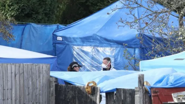 Police forensics tents in a back garden