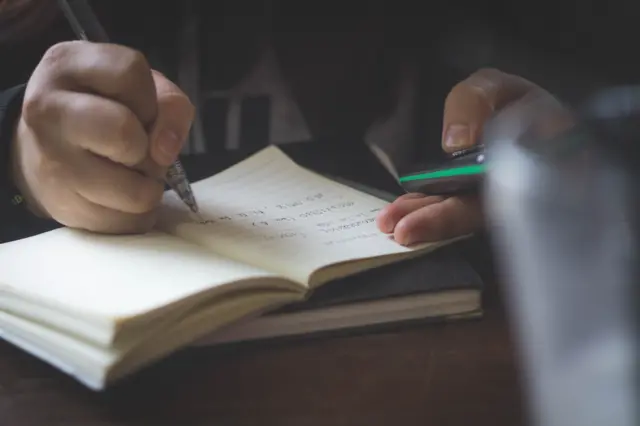 Pupil writing in exercise book