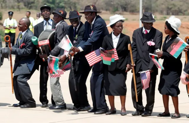 Malawians hold flags as U.S. first lady Melania Trump arrives in Lilongwe, Malawi, October 4, 2018