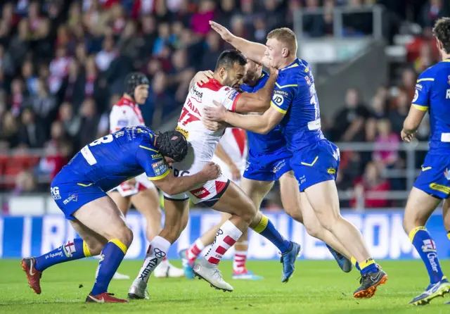 St Helens' Dominique Peyroux is tackled by Warrington's Chris Hill and Jack Hughes.