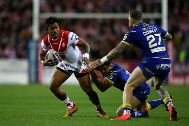 Ben Barba of St Helens is tackled by Toby King and Josh Charnley