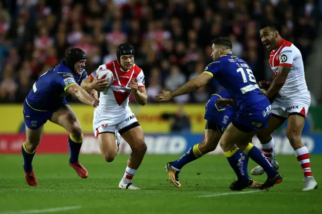 Jonny Lomax of St Helens crashes through the tackle of Chris Hill and Toby King of Warrington