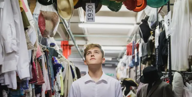 A teenager in a clothes warehouse