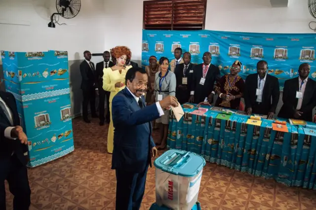 Cameroon's incumbent President Paul Biya (C) casts his ballot as his wife Chantal looks on in the polling station in Bastos neighbourhood in the capital Yaounde, on October 7, 2018 during Cameroon's presidential election.