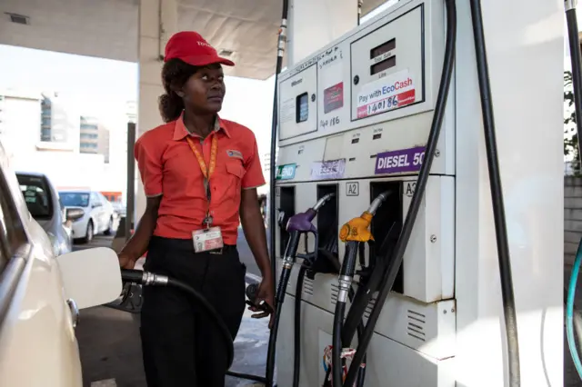 A filling station attendant fills a car with fuel at a petrol station on July 30, 2018 in Harare, Zimbabwe.