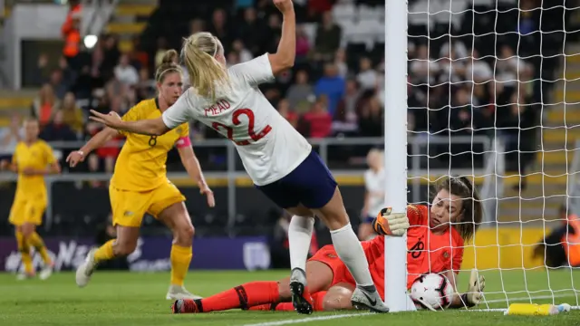 Mackenzie Arnold of Australia gathers the ball under pressure from Beth Mead