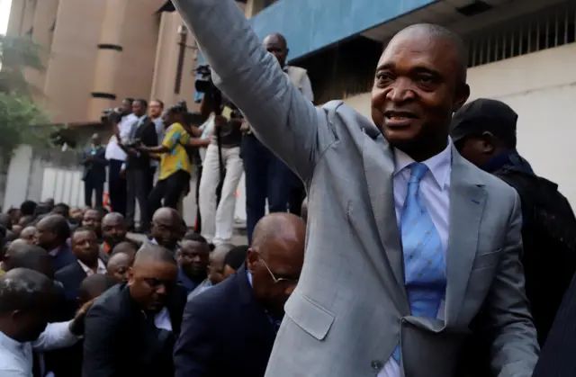 Former Congolese interior minister Emmanuel Ramazani Shadary waves to his supporters as he arrives to file his candidacy for the presidential election