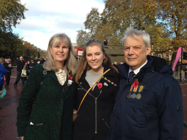 Jeremy Cripps wearing his grandfather's medals alongside his wife Carol and daughter Jessica