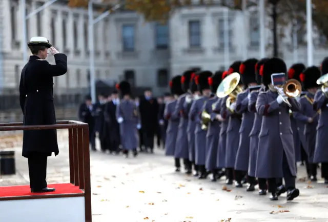 Princess Anne salutes military personnel as they march on Horse Guards Parade