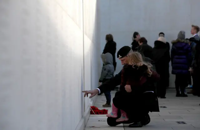 A veteran hugs a girl at the National Memorial Arboretum