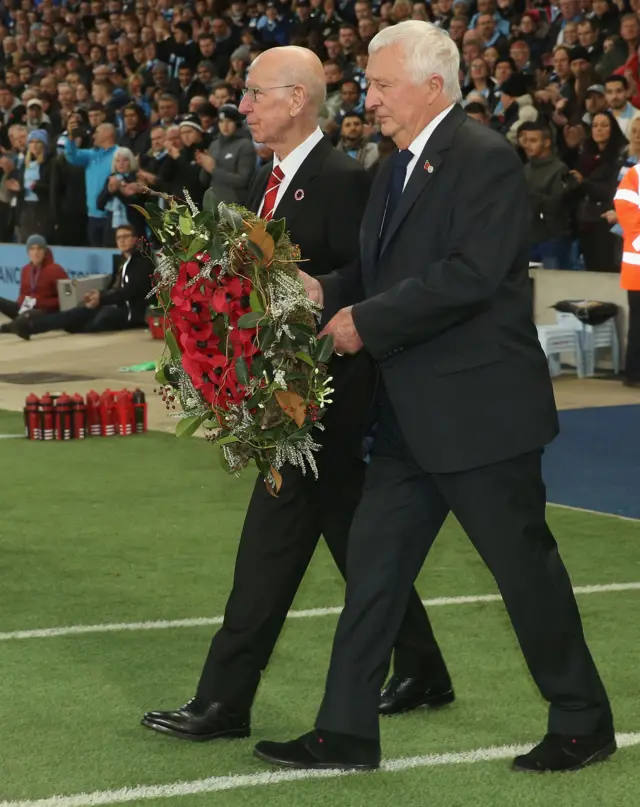 Former United player Sir Bobby Charlton and City's Mike Summerbee lay a wreath