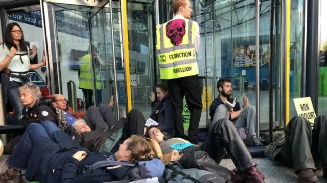 Protesters lay chained together on the pavement outside the UK government's energy department