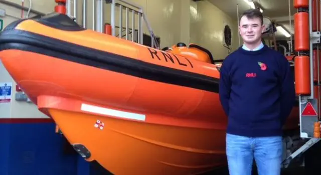 Will Bell standing next to a lifeboat