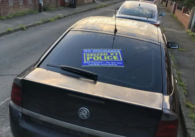 A car with a sticker on it saying no insurance