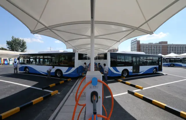 All-electric buses stand at a parking lot