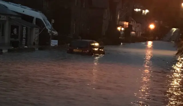 Windermere Road flooded at night, with car that's got water up to the wheel arches