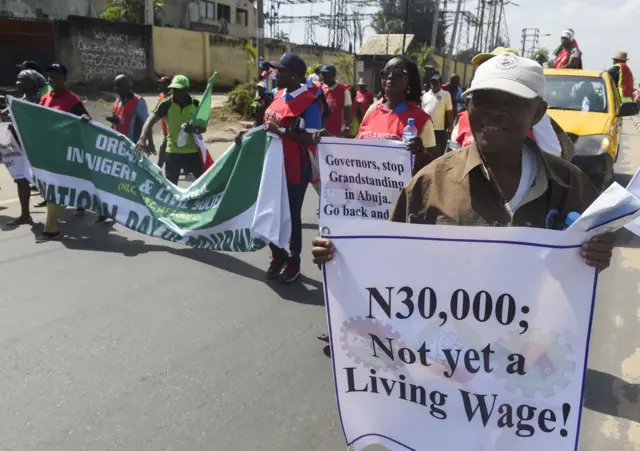 Workers carry banners reading "N30,000 Not yet a living wage!" to protest against government failure to agree on the new minimum wage during a rally in Lagos, on October 30, 2018. - Workers across Nigeria march to protest government"s delay in agreeing on a new minimum wage and threaten to embark on nationwide strike if the authorities fail to meet their demand by November 6, 2018.