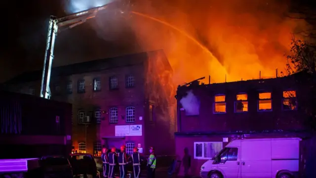 Firefighters hosing down factory