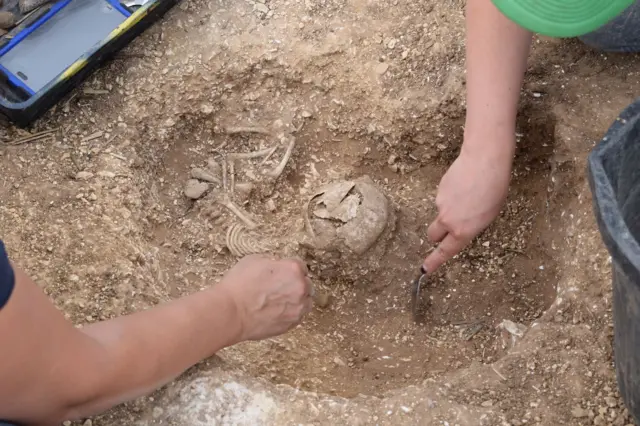 Picture of two people excavating a neonatal burial