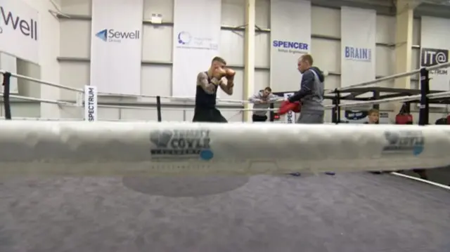 Two people boxing as Tommy Coyle watches