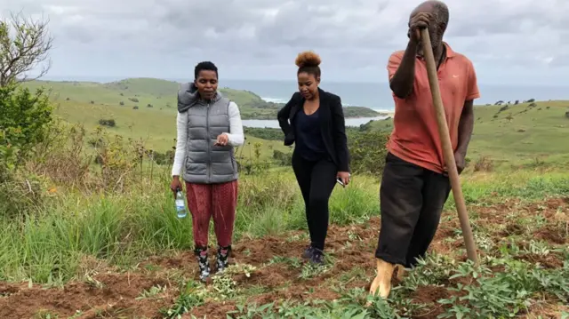 ACC leader Nonhle Mbuthuma (L) stands next to the BBC's Pumza Filhani on the Xolobeni community's land.