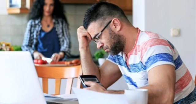 man looking at calculator