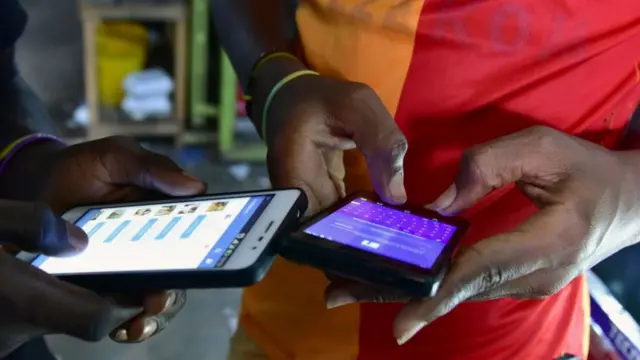 Two men use their smarphones