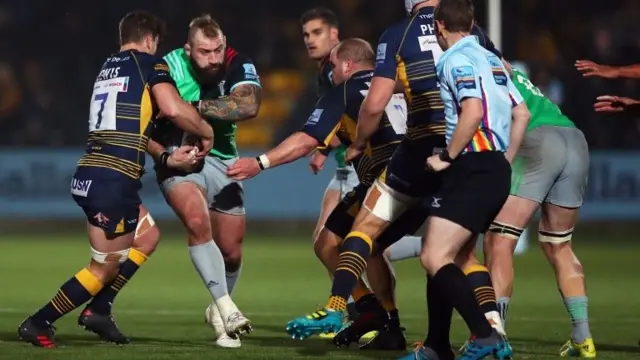 Worcester players tackling Harlequins' Joe Marler