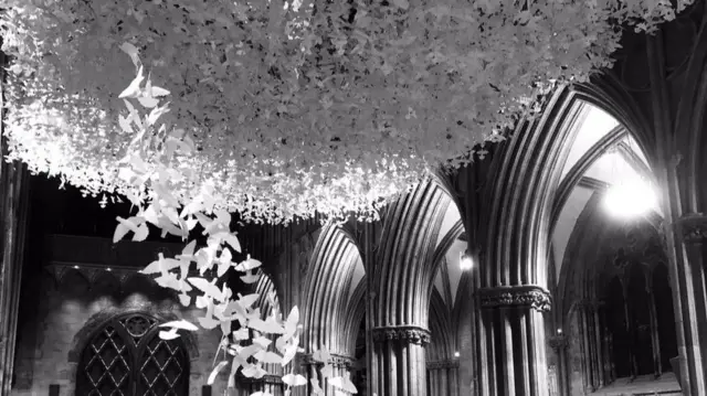 The paper doves hanging from the cathedral's ceiling