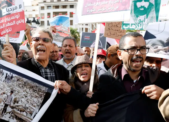 People chant slogans and hold banners as they take part in a protest, opposing the visit of Saudi Arabia"s Crown Prince Mohammed bin Salman in Tunis.