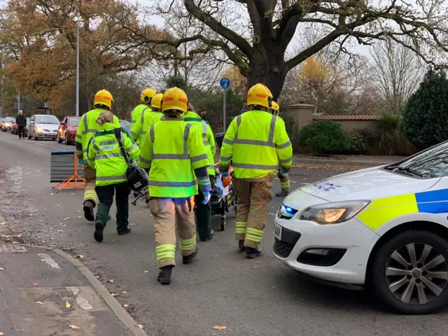 firefighters and ambulance crew treat patient