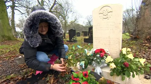 Debi Allbutt next to the grave