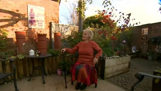 Iris Newbould sitting in her garden