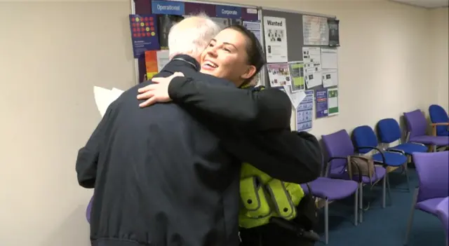 A police officer hugs a man